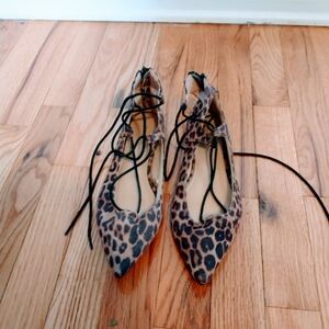 Express leopard print flats with pointed toe. Lace up ankle and zipper in the ba